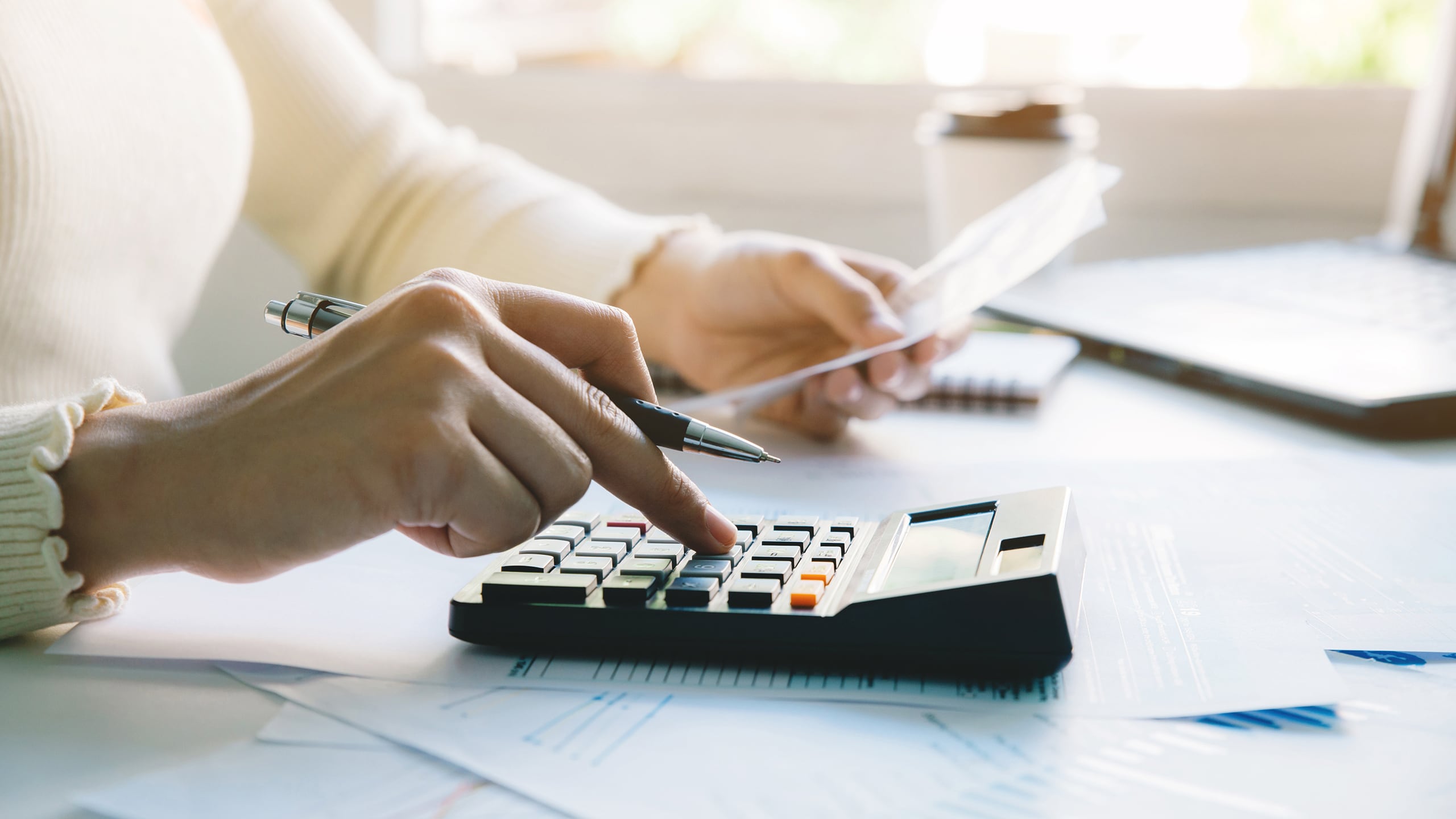 women using calculator in an office