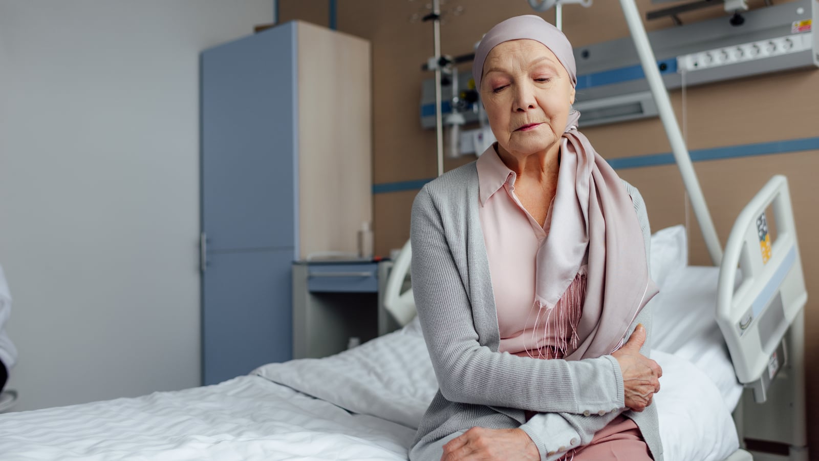 Woman with head scarf sitting on a hospital bed
